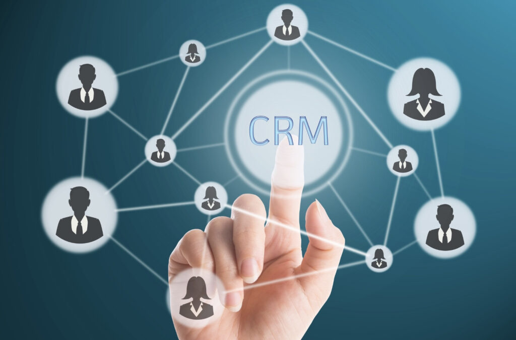 Hand pointing to a CRM icon surrounded by a network of business avatars