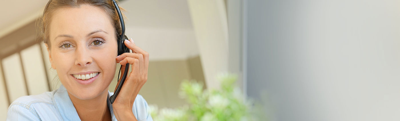 Smiling woman wearing headset assisting customers